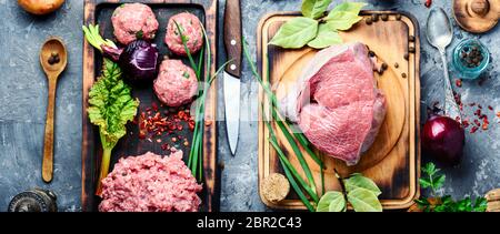 Boulettes de viande de boeuf cru vigueur-viande sur conseil de cuisine.La viande crue sélection sur planche à découper en bois Banque D'Images