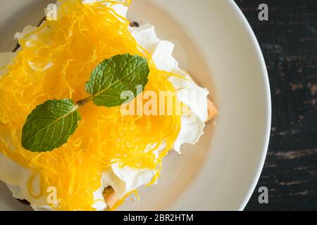 Golden Egg Yolk Threads ou Foi Thong Toast et crème fouettée et de chocolat. Dessert thaïlandais d'œuf d'or threads ou foi thong avec peppermint sur whipp Banque D'Images