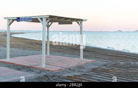 Arbor pour fauteuil roulant, usage exclusif à la plage de Los Narejos en Espagne. Endroits dans la plage pour les personnes avec des désabilitéle signe est bleu sur un bac blanc Banque D'Images