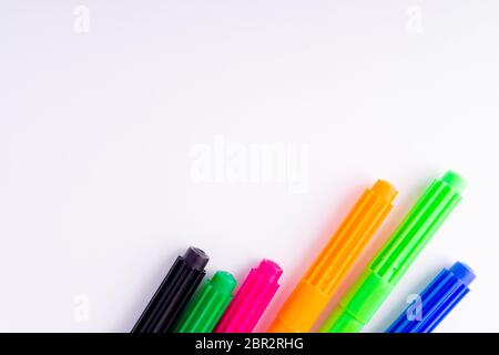 Crayons de couleur gros plan isolés sur fond blanc avec mise au point sélective et fragment de recadrage. Retour à l'école et concept d'éducation. Banque D'Images