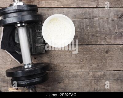 Avec haltère protein shake sur un plancher en bois rustique, vue d'en haut Banque D'Images