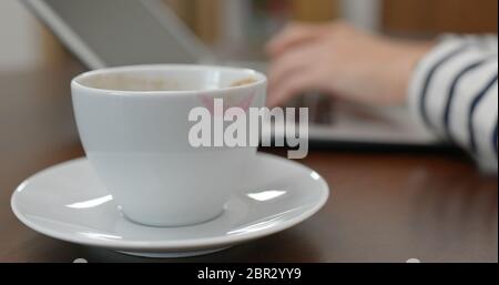 Type d'ordinateur portable, avec une marque rouge sur une tasse à café Banque D'Images