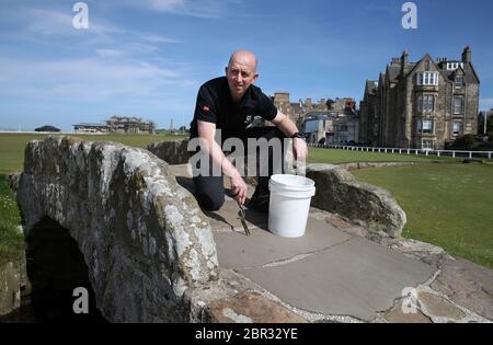 Directeur du Green Keeping à St Andrews Links Trust Sandy Reid adventices sur le pont Swilcan sur le vieux parcours de St Andrews. Le premier ministre Nicola Sturgeon doit annoncer jeudi une « carte de route » pour lever le blocage du coronavirus en Écosse Banque D'Images