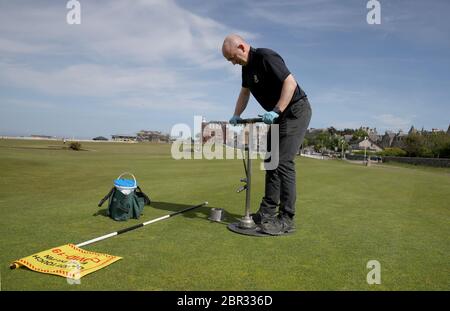 Directeur du Green Keeping à St Andrews Links Trust Sandy Reid coupant un trou sur le 17e vert sur le Old course à St Andrews. Le premier ministre Nicola Sturgeon doit annoncer jeudi une « carte de route » pour lever le blocage du coronavirus en Écosse Banque D'Images