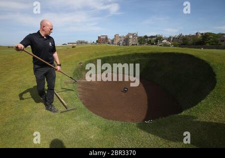 Directeur du Green Keeping à St Andrews Links Trust Sandy Reid rakes le bunker de Road Hole au 17e green sur le Old course à St Andrews. Le premier ministre Nicola Sturgeon doit annoncer jeudi une « carte de route » pour lever le blocage du coronavirus en Écosse Banque D'Images