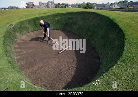 Directeur du Green Keeping à St Andrews Links Trust Sandy Reid rakes le bunker de Road Hole au 17e green sur le Old course à St Andrews. Le premier ministre Nicola Sturgeon doit annoncer jeudi une « carte de route » pour lever le blocage du coronavirus en Écosse Banque D'Images