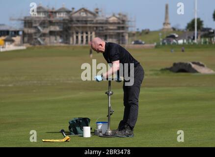 Directeur du Green Keeping à St Andrews Links Trust Sandy Reid coupant un trou sur le 17e vert sur le Old course à St Andrews. Le premier ministre Nicola Sturgeon doit annoncer jeudi une « carte de route » pour lever le blocage du coronavirus en Écosse Banque D'Images