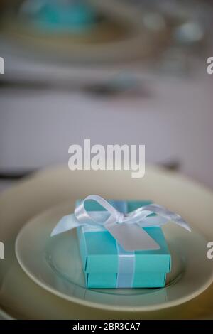 Table de fête avec boîte cadeau fait main sur la plaque. Boîte cadeau fait main bleu clair dans la plaque sur la table de mariage. Banque D'Images