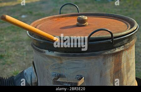 Cuisinière en baril et grand pot avec cuillère en bois avec un pic de c Banque D'Images