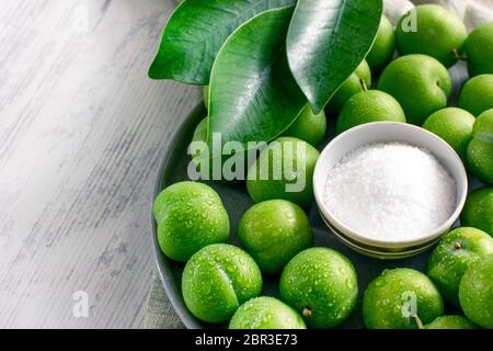 Prunes vert acide non mûres avec sel. En-cas turc traditionnel. Banque D'Images