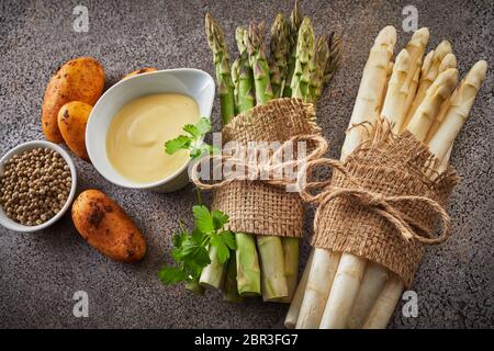 Ingrédients pour une entrée d'asperges gastronomique avec des paquets de blanc et vert frais spears, mayonnaise, pommes de terre et le poivre Banque D'Images