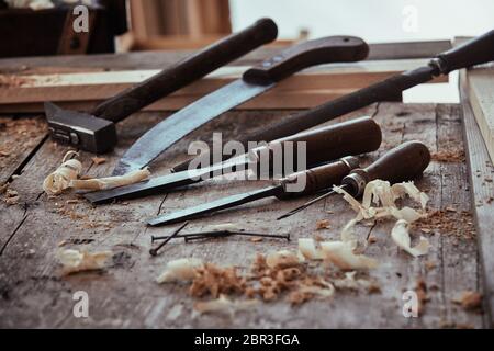 Portrait d'un atelier de travail du bois rustique avec de vieux outils à main vintage y compris les ciseaux, marteau, scie et rasp ou fichier sur l'établi Banque D'Images