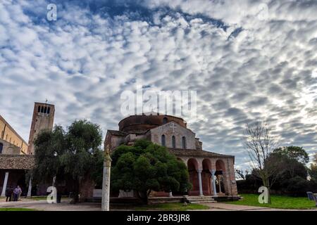 Vue sur la cathédrale de Torcello (basilique de Santa Maria Assunta), l'église de Santa Fosca et le clocher, sur des arbres verts sous ciel bleu, sur l'île Banque D'Images