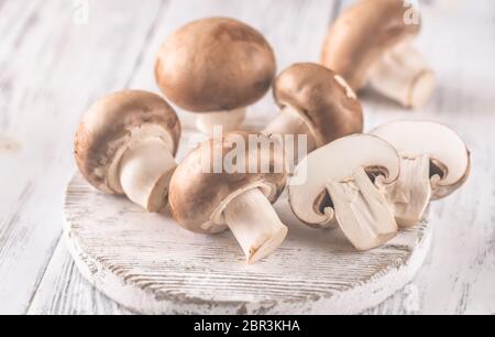Champignon champignons - ensemble et ceux de moitié- sur la planche de bois blanc Banque D'Images