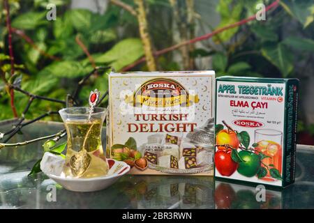 Thé turc aux pommes et bonbons (délices turcs), servis sur une table en verre dans un jardin Banque D'Images