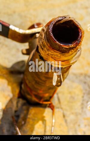 Close up image d'une goutte de l'eau qui goutte d'un robinet rouillé. Image peut être utilisé pour illustrer les économies d'eau. Banque D'Images