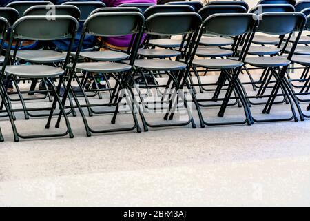 Des rangées de chaises pliantes noir vide dans une salle de conférence Banque D'Images