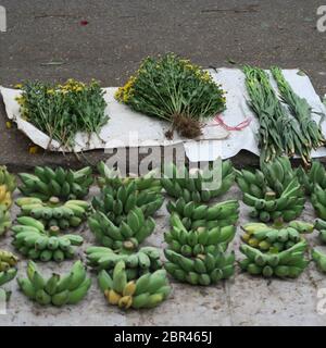 Bananes et fleurs sur papier à vendre dans une rue au Vietnam Banque D'Images