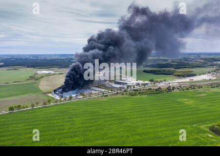 Vue du haut vers le bas de nuages de fumée des feux de l'entrepôt avec toit brûlé, l'incendie survenu en catastrophe entrepôt logistique du fret Banque D'Images