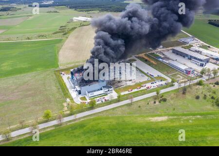 Vue du haut vers le bas de nuages de fumée des feux de l'entrepôt avec toit brûlé, l'incendie survenu en catastrophe entrepôt logistique du fret Banque D'Images