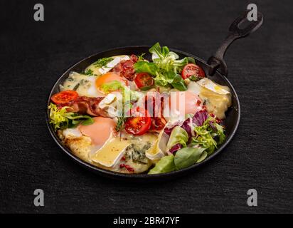 Délicieux petit déjeuner avec des œufs au plat, bacon, laitue et resineaux petit camembert Banque D'Images