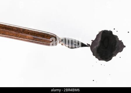 Vue de dessus de nib peint noir porte-plume encre brune sur blot sur papier blanc Banque D'Images