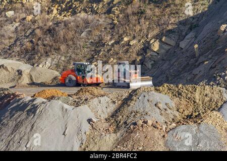 Bulldozer compacteur rouleau et en ambiance colline pierreuse Banque D'Images