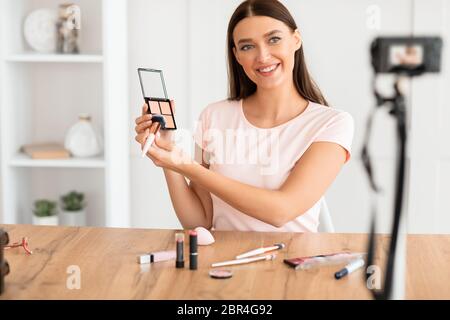 Beauté Blogger fille faire de la vidéo de revue des produits cosmétiques à la maison Banque D'Images