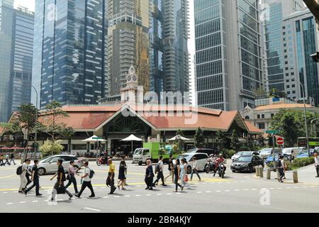 Piétons traversant une rue animée dans le quartier central des affaires de Singapour. Banque D'Images