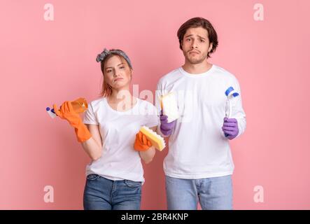 Nettoyage des minerais. Mécontent l'homme et la femme avec des outils ménagers en mains Banque D'Images