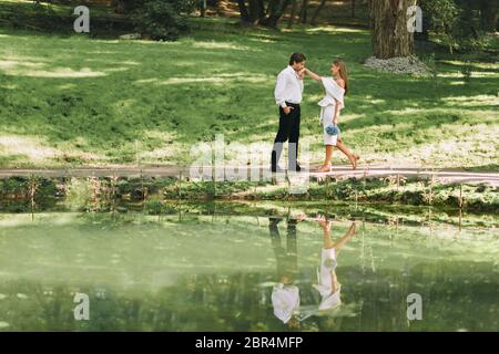 Le marié Kissing Bride se tient près du lac dans le parc extérieur Banque D'Images