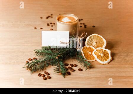 Composition d'une tasse de latte, de grains de café, d'oranges séchées et d'une branche de sapin Banque D'Images