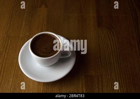 Café avec du lait dans une tasse blanche placée sur une table marron Banque D'Images