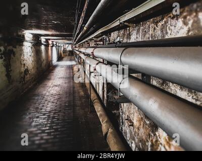 tuyaux sur le mur du tunnel d'entretien souterrain . Banque D'Images