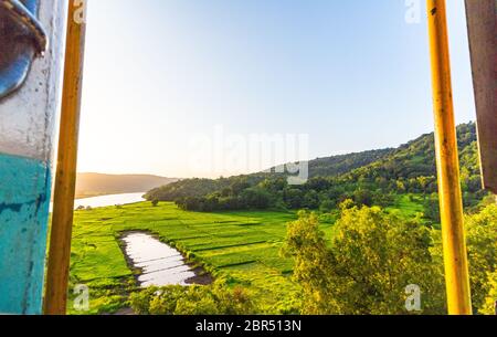 Nature verte avec ciel bleu clair au milieu de voyage de Goa à Mumbai en train. Le coucher de soleil autour d'une rivière dans la région de Goa tout en ayant un voyage en train. Banque D'Images