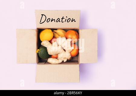 Boîte de dons avec divers aliments. Ouvrez la boîte en carton contenant les fruits pour le système immunitaire. Copier l'espace. Banque D'Images