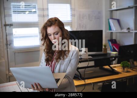 Femme d'affaires caucasienne travaillant dans un bureau moderne décontracté Banque D'Images