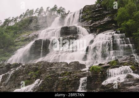 Vue sur la cascade de Tvindefossen ou Tvinnefossen près de Voss, Norvège. Naturel, paysage. Camping Tvinde. Marquise, rochers Banque D'Images