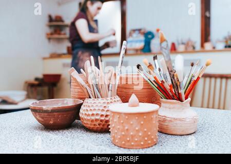 Maître de céramique se prépare à peindre la poterie. Potier dans l'atelier Banque D'Images