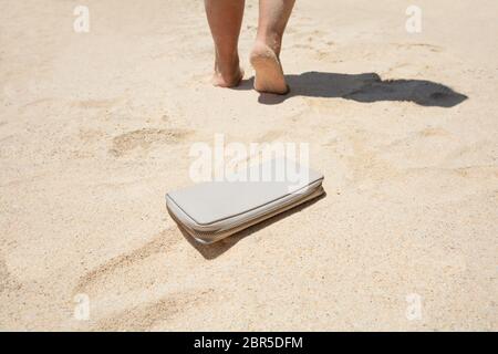 Close-up of a Woman a perdu une bourse avec de l'argent sur la plage de sable Banque D'Images