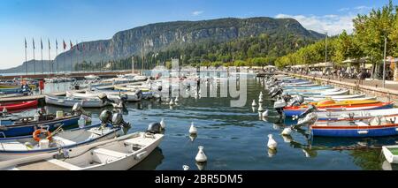 LAC DE GARDE, ITALIE - SEPTEMBRE 2018 : vue panoramique sur les petits bateaux de pêche alignés dans le port de la ville de Garda sur le lac de Garde. Banque D'Images