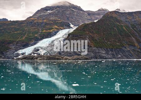 Glacier en cascade se reflétant dans les eaux du bras Barry dans le fjord Harriman, baie Prince William, près de Whittier, en Alaska. Banque D'Images