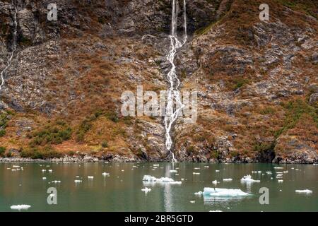 L'eau de fonte descend en cascade le long du mont Gilbert depuis le glacier Serpentine, dans le bras Barry, dans le fjord Harriman, près de Whittier, en Alaska. Le glacier a rechapé de façon spectaculaire d'un glacier d'eau tidale à devenir un glacier suspendu. Banque D'Images