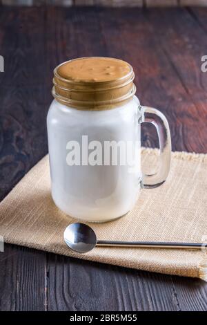 Café Dalgona avec une mousse fouettée douce et fraîche. Latte espresso dans un verre transparent sur un comptoir en ardoise grise. Dalgona est une boisson sud-coréenne avec du Whipp Banque D'Images