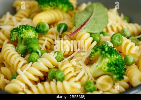 Pâtes avec brocoli et pois verts dans un plat de gros plan Banque D'Images