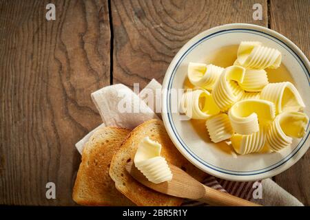 Plat de beurre avec des boucles d'or croustillant Pain grillé servi sur une table en bois rustique avec des pailles et des serviettes Banque D'Images