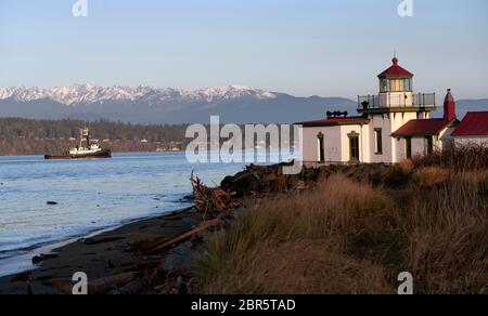 Un bateau passe dans le phare de Bonaventure de West Point à l'aube de Puget Sound Banque D'Images