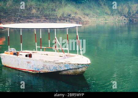 Bateau en bois blanc à river bank, entouré de forêts de mangrove. Jungle Cruise Delta du fleuve. Pêcheur et barques touristiques. Inde tourisme Asam Banque D'Images