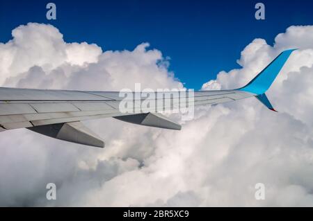 Ailes d'un avion dans un mélange de ciel ciel bleu et nuages Banque D'Images