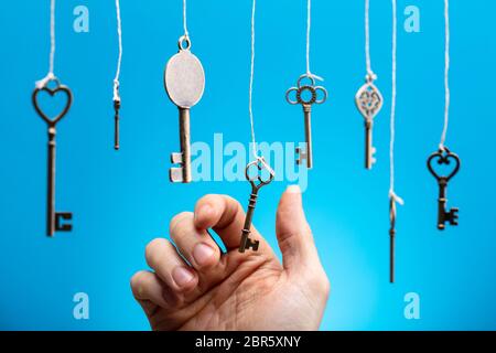 Close-up of Person's Hand choisir une clé suspendue entre autres Banque D'Images